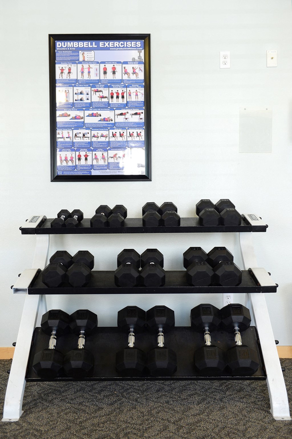 a row of boxing weights on a shelf with a framed poster on the wall at Hearthstone Apartments and Townhomes, Apple Valley, Minnesota