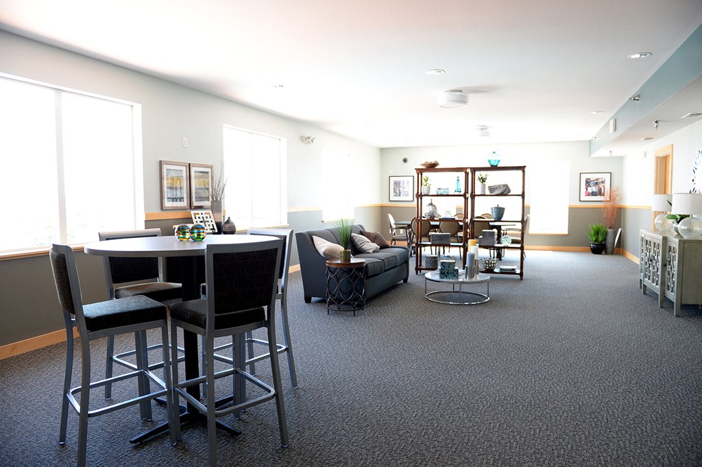 an open concept living room and dining area with a table and chairs at Hearthstone Apartments and Townhomes, Apple Valley, MN