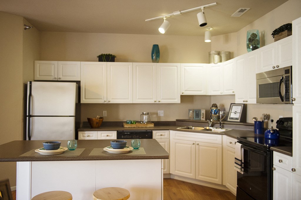 a kitchen with white cabinets and black appliances at Hearthstone Apartments and Townhomes, Apple Valley, 55124