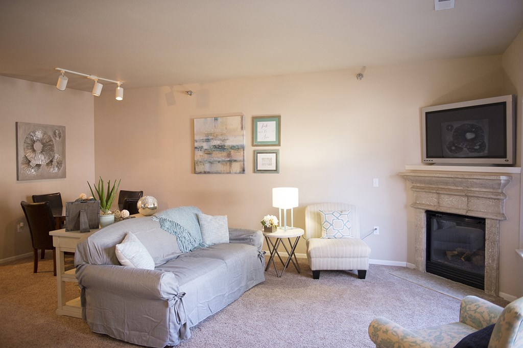 a living room with a couch a chair and a fireplace at Hearthstone Apartments and Townhomes, Minnesota