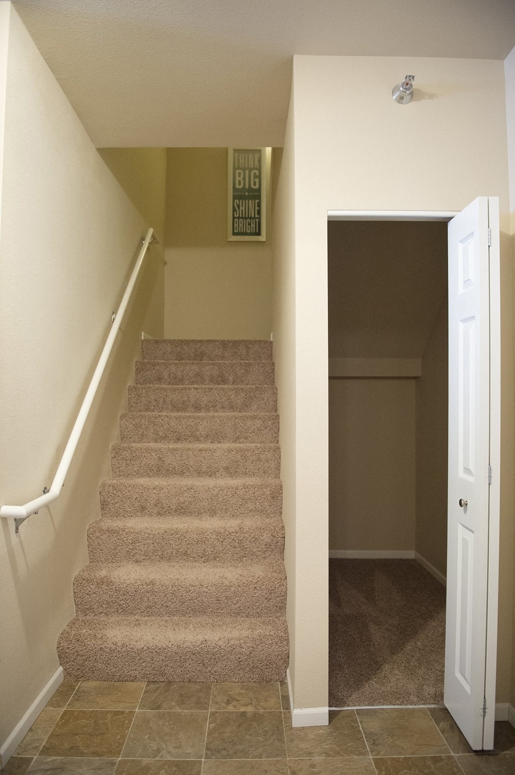 a carpeted staircase in a home and a closet at the bottom of it at Hearthstone Apartments and Townhomes, Minnesota