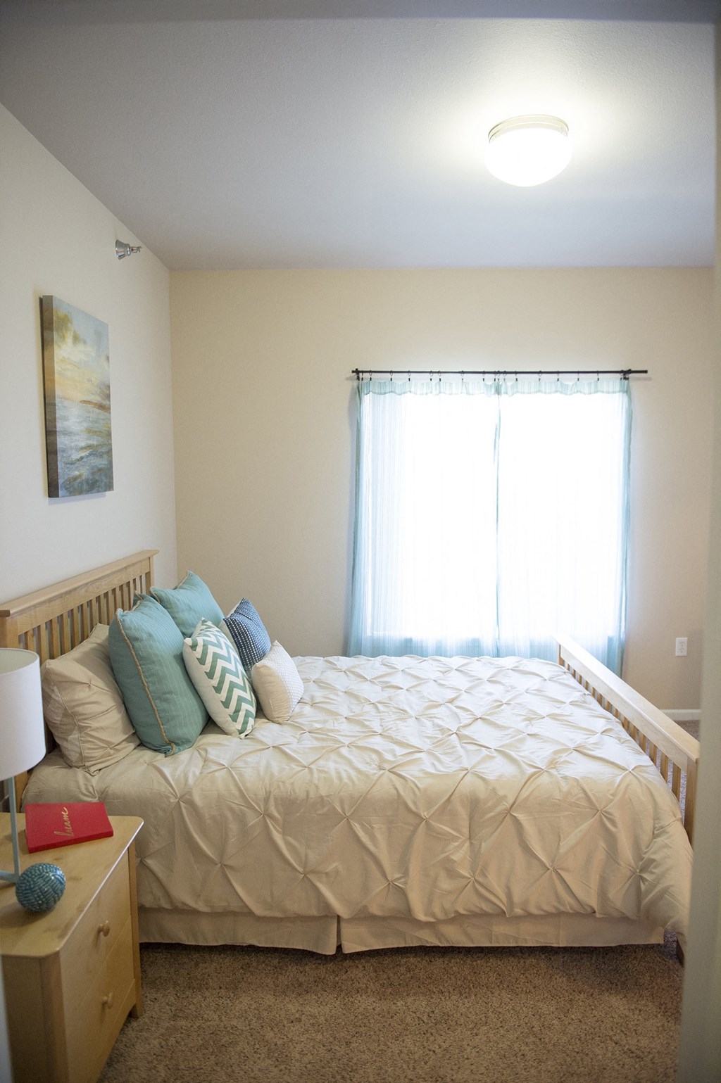 a bedroom with a bed and a dresser at Hearthstone Apartments and Townhomes, Minnesota