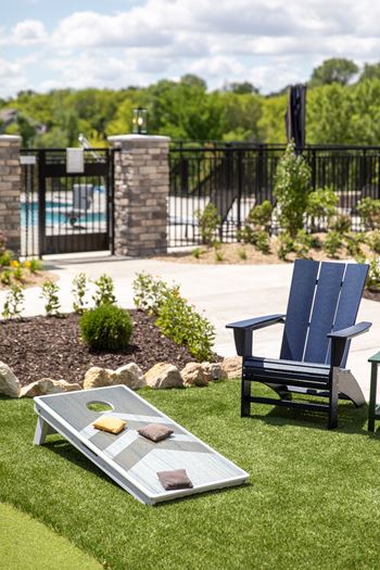 a patio with two chairs and a table on the grass