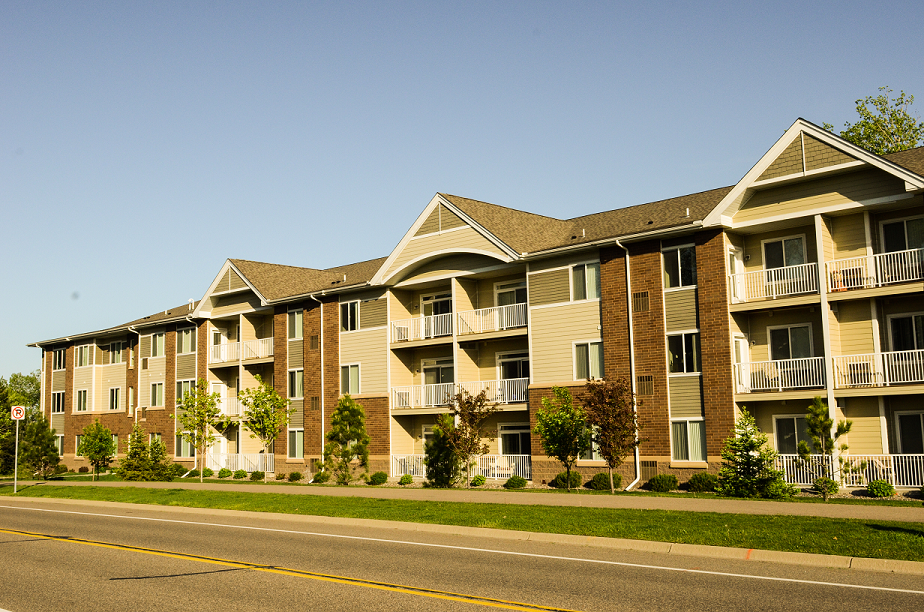 a row of apartment buildings on the side of a road