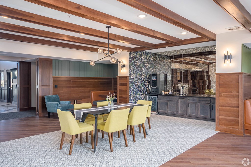 a dining room with a glass table and yellow chairs