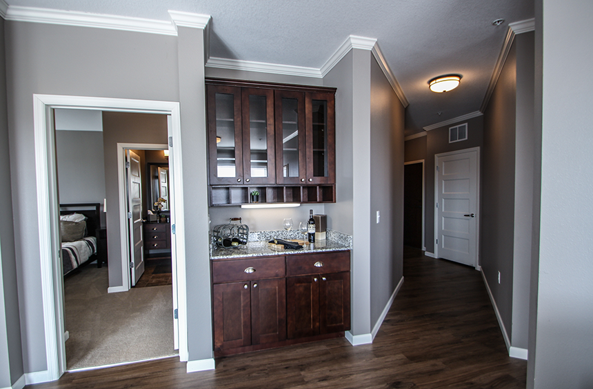 a kitchen with dark wood cabinets and granite countertops  at Victoria Park and V2 Apartments, St. Paul, Minnesota