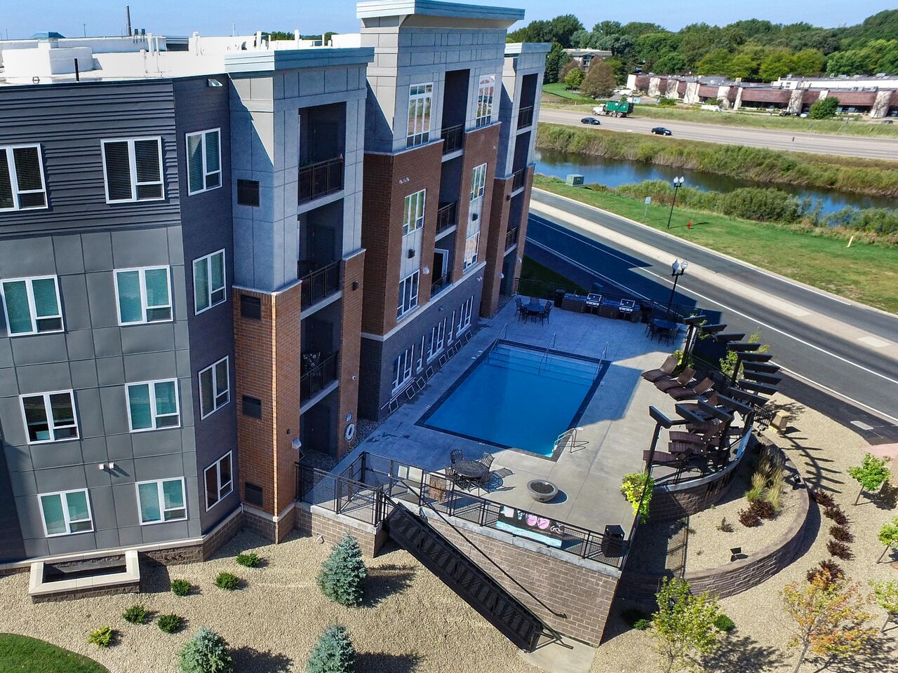 an aerial view of a building with a pool in front of it at The Flats at Cedar Grove, Eagan