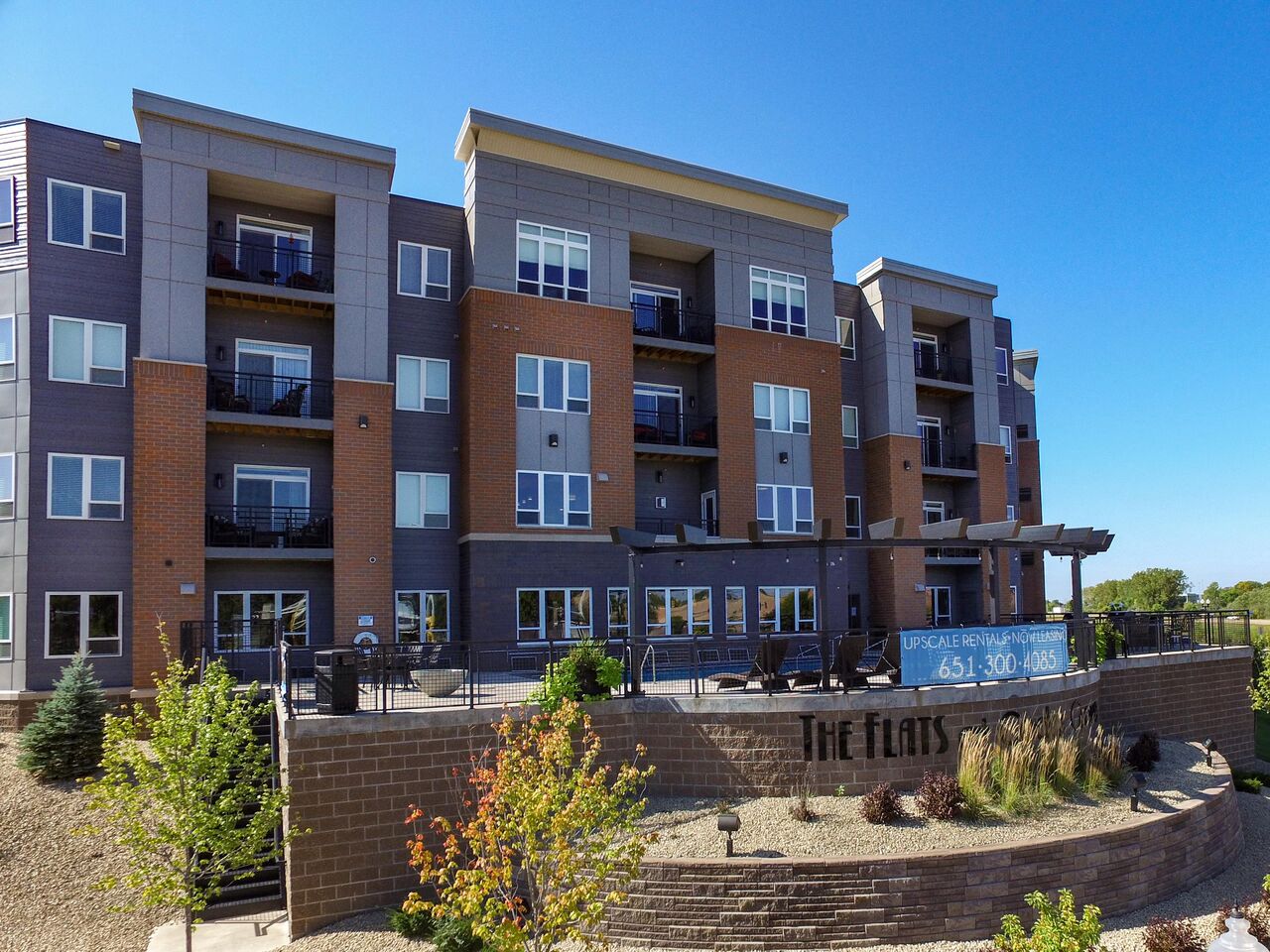 a large apartment building with a sign that reads the flats at The Flats at Cedar Grove, Eagan, 55122