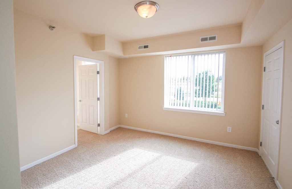 an empty bedroom with a large window