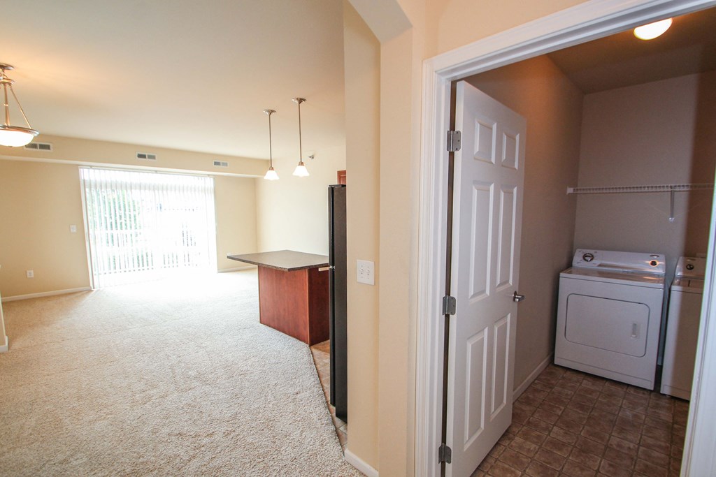 a living room with a door to washer and dryer room