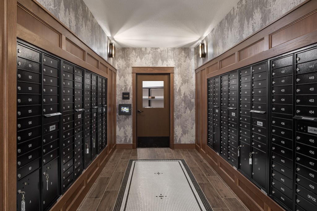 A hallway with a row of lockers on both sides and a door in the middle.