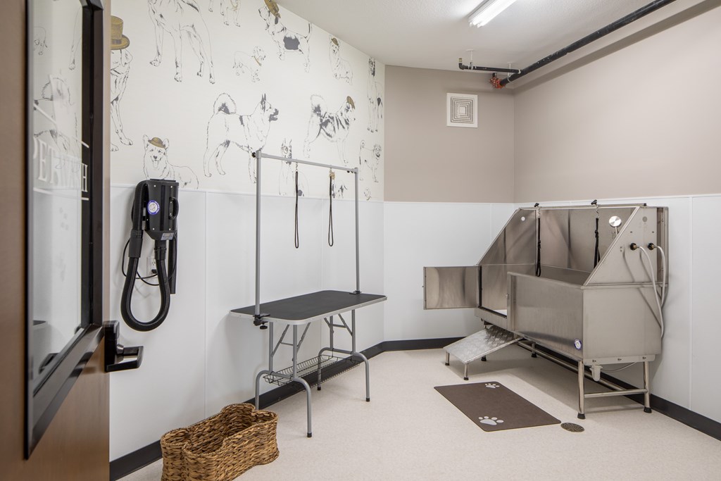 A room with a table, chairs and a wall with drawings on it.
