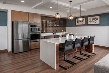 A modern kitchen with a large island and stainless steel appliances.