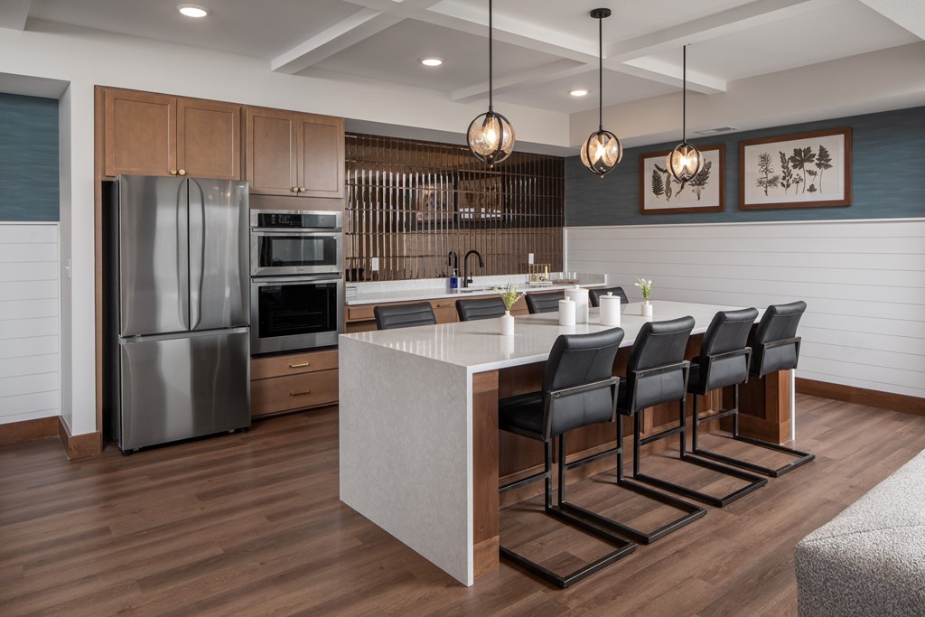 A modern kitchen with a large island and stainless steel appliances.