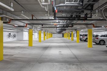 A parking garage with yellow poles and white walls.