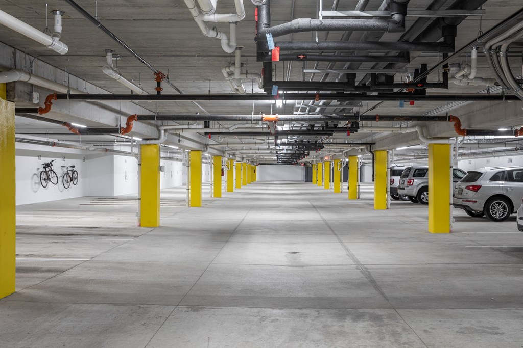 A parking garage with yellow poles and white walls.