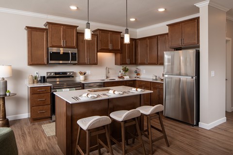 A kitchen with wooden cabinets and a stainless steel refrigerator.