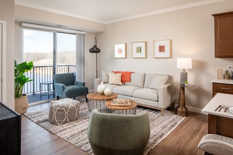 A living room with a white couch and a grey ottoman.