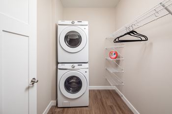 A white laundry room with a washer and dryer stacked on top of each other.