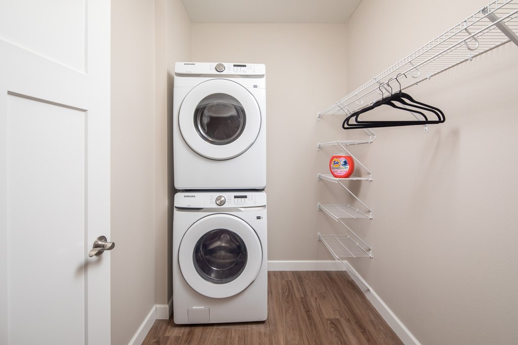 A white laundry room with a washer and dryer stacked on top of each other.