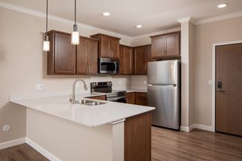 A kitchen with a white counter top and wooden cabinets.