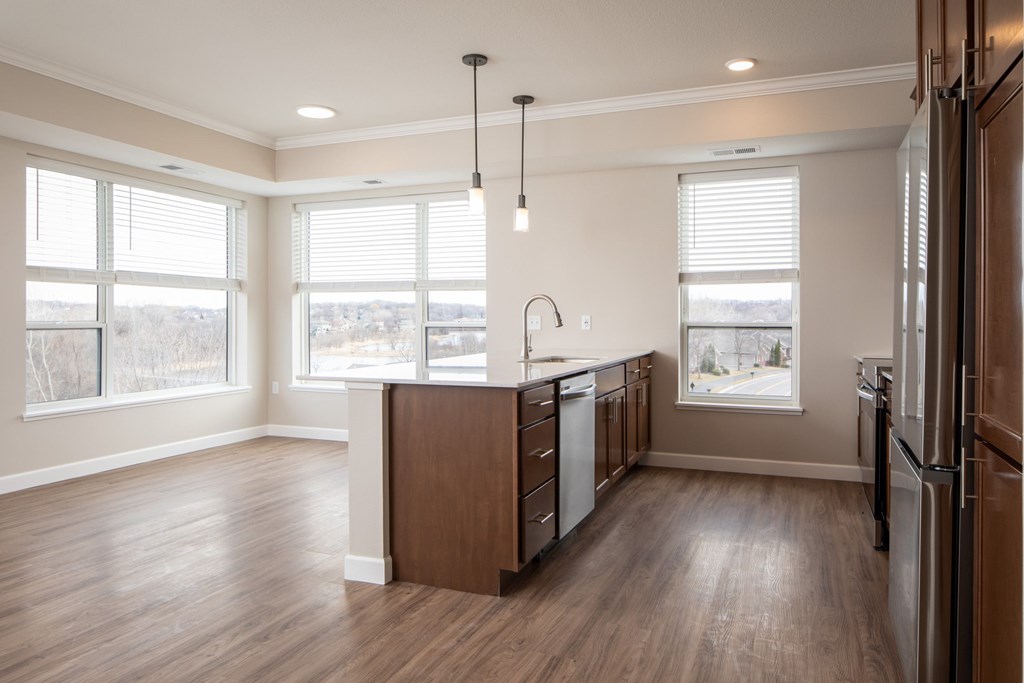 A kitchen with wooden floors and a large island with a sink.