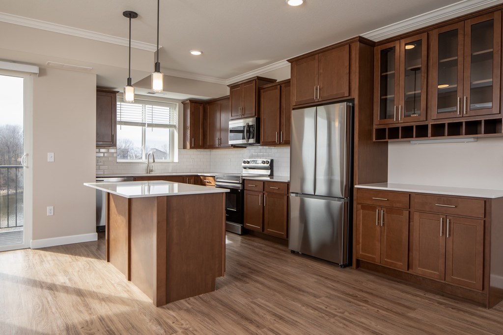 A modern kitchen with wooden cabinets and a stainless steel refrigerator.