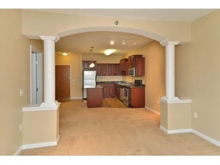 a view of a living room and kitchen with a stove top oven next to a doorway
