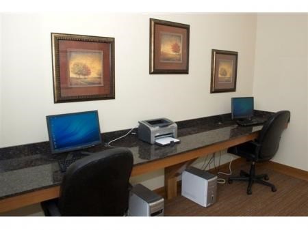 commuter room with a desk with two computers on it and three pictures on the wall