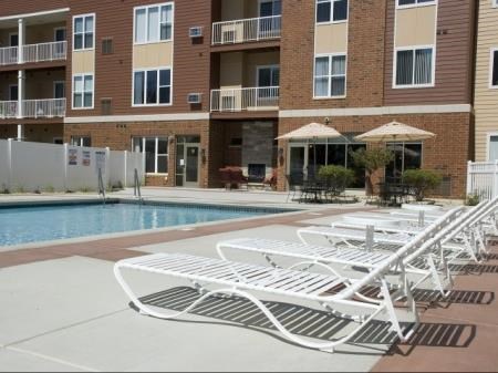 a pool with white lounge chairs