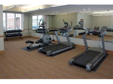 a fitness room with treadmills and other exercise equipment