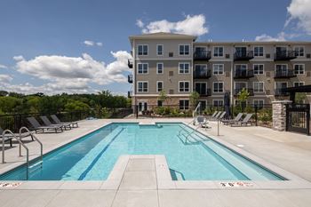 a swimming pool with an apartment building in the background