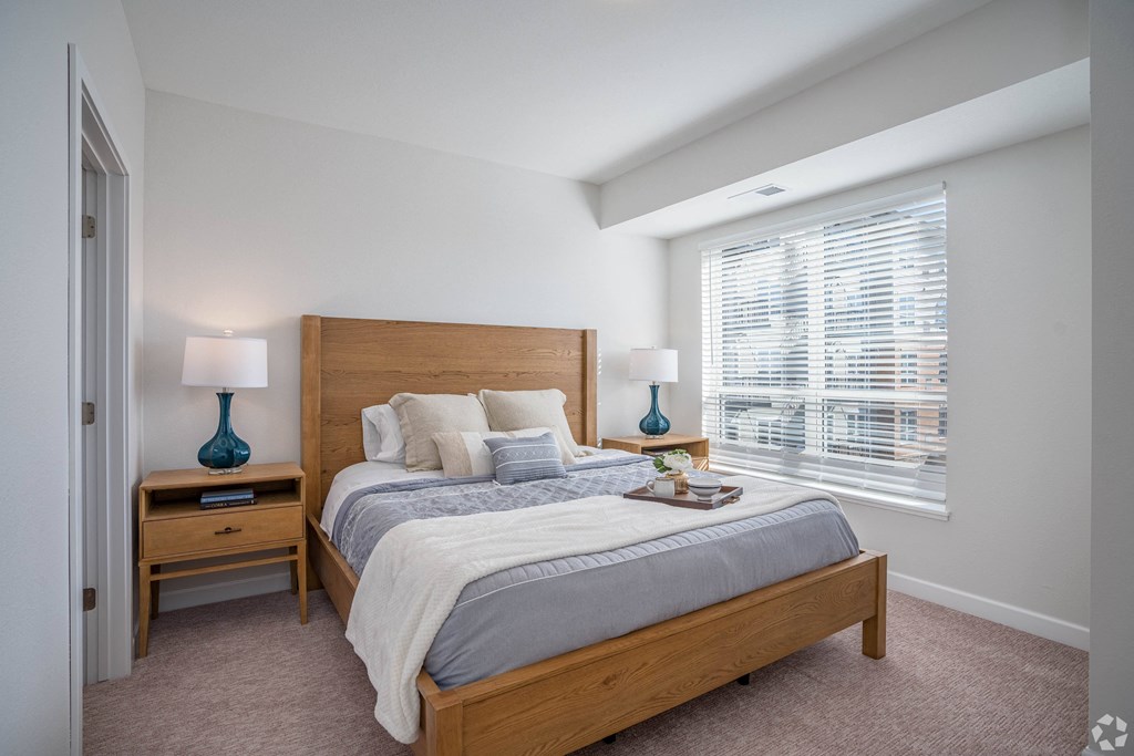 a bedroom with a bed and a large window