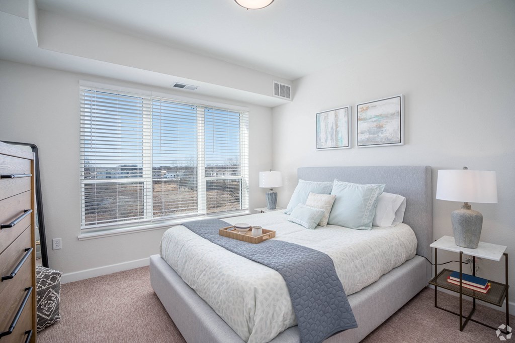 a bedroom with a bed and a large window