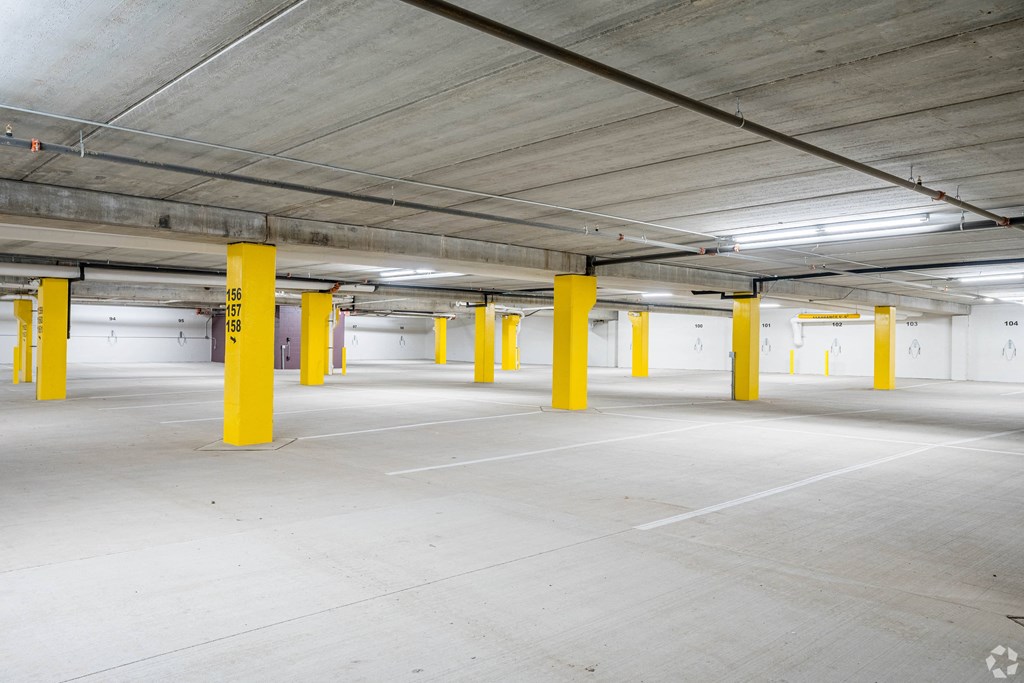 an empty parking garage with yellow pillars in it