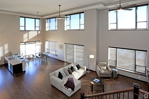 A large open living room with a white couch and a dining table.