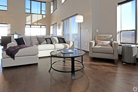 A modern living room with a white couch and a glass coffee table.