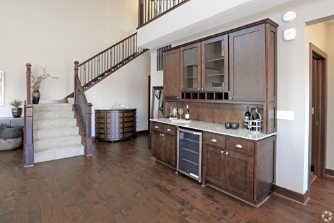 A kitchen with dark wood cabinets and a staircase with a metal railing.