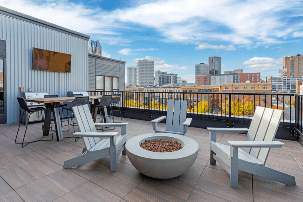 Rooftop deck with lounge seating and gas firepit overlooking park and skyline. at The Whitley, St. Paul