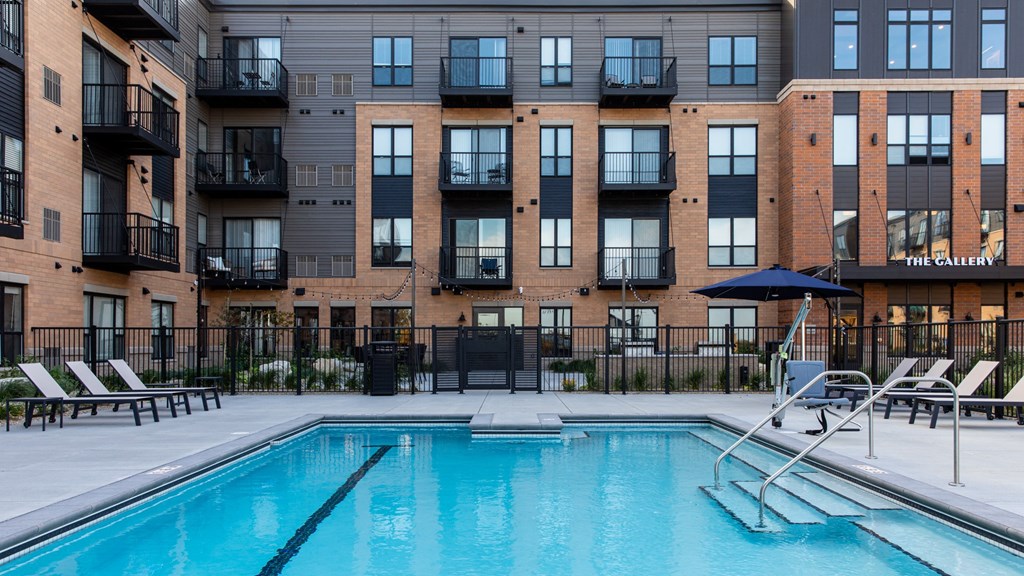 a pool with a brick building in the background at The Gallery Apartments, Burnsville, MN