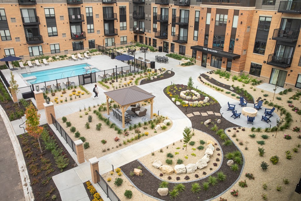an aerial view of an apartment complex with a pool and patio at The Gallery Apartments, Burnsville, MN