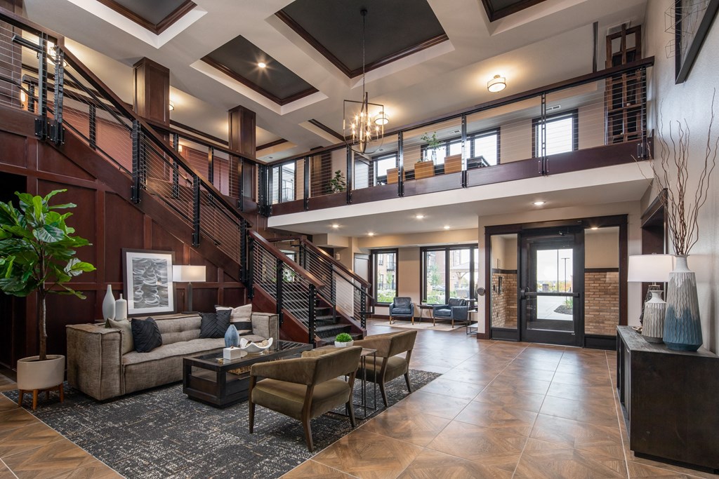 a reception area with couches a coffee table and a stairway to the second floor at The Gallery Apartments, Burnsville, Minnesota