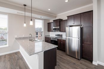 a kitchen with a large island and stainless steel appliancesat The Carver Apartments, Chaska, MN