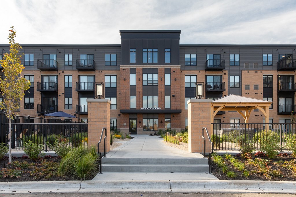 a picture of the front of a building with a walkway and gazebo at The Gallery Apartments, Burnsville, Minnesota