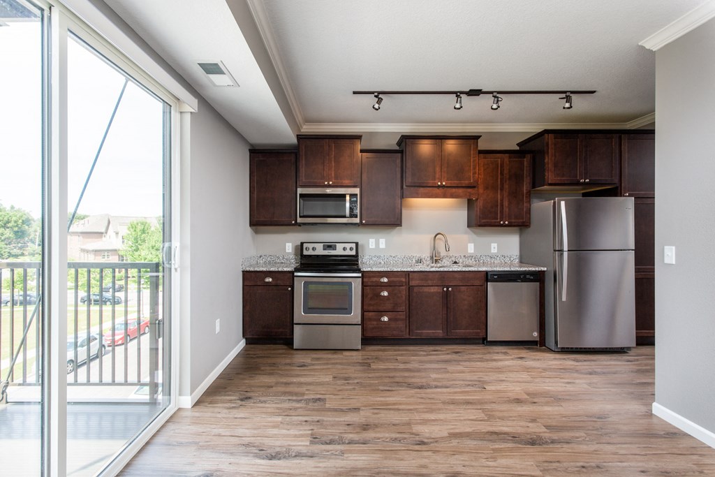 a kitchen with dark wood cabinets and stainless steel appliances  at Victoria Park and V2 Apartments, Minnesota