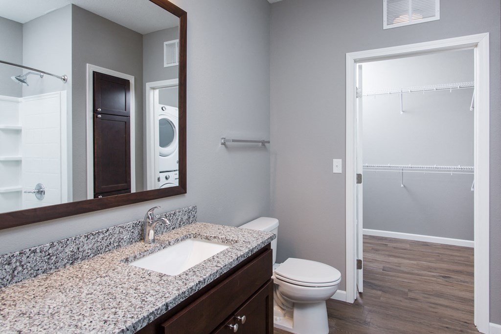 a bathroom with a toilet sink and mirror  at Victoria Park and V2 Apartments, Minnesota