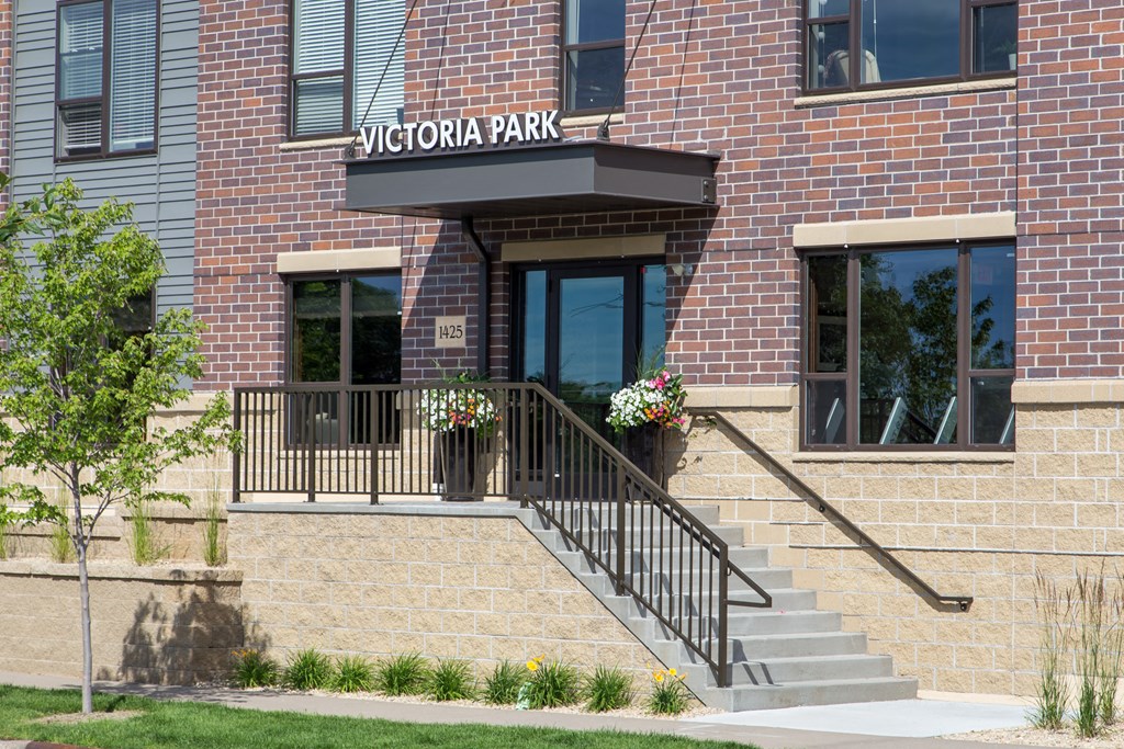 the entrance of a brick building with a sign that says victoria park  at Victoria Park and V2 Apartments, Minnesota, 55102