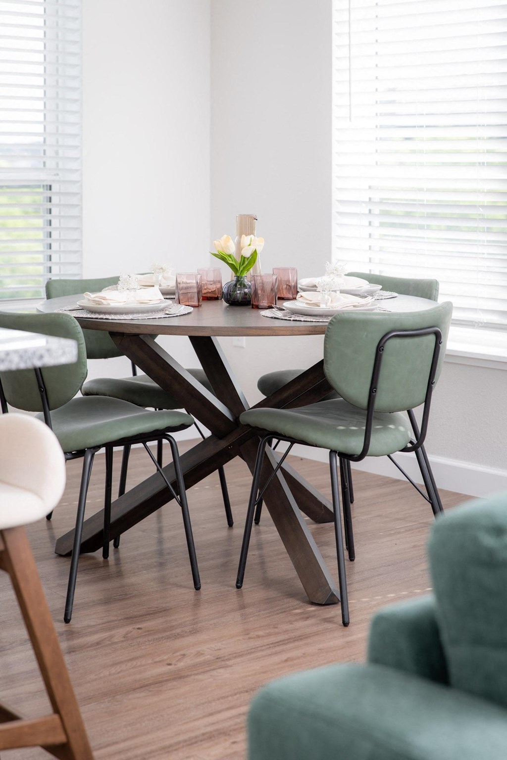 a dining room with a wooden table and green chairs