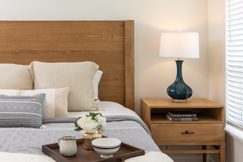 Bedroom with wood headboard and nightstand at The Carver Apartments, Minnesota