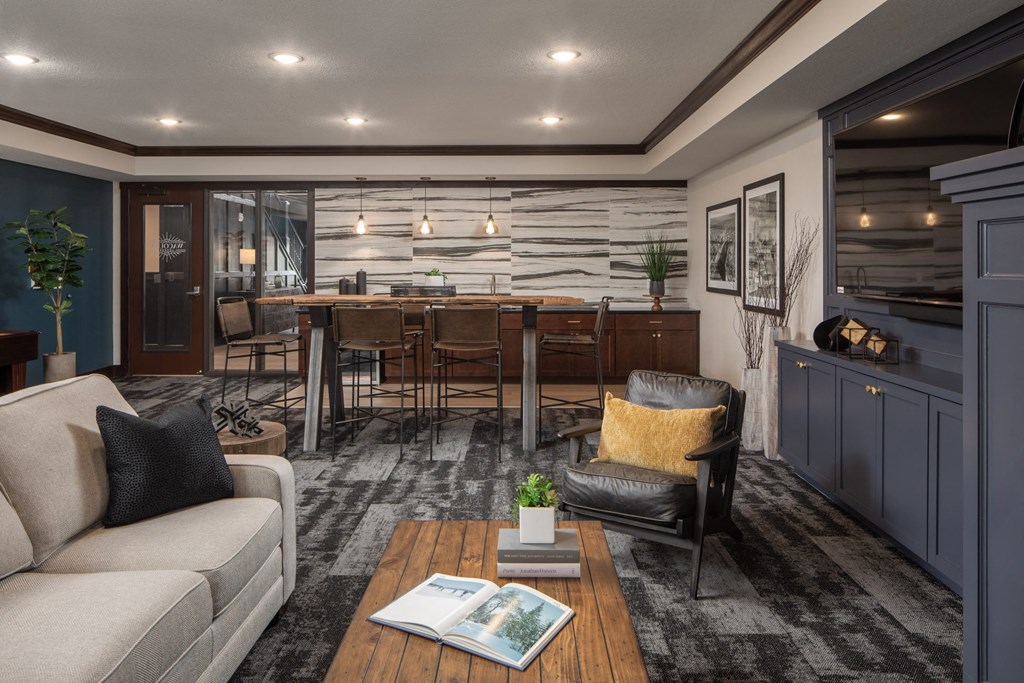 Lounge area with couch, tables, and chairs, with breakfast bar  at The Whitley, St. Paul, MN